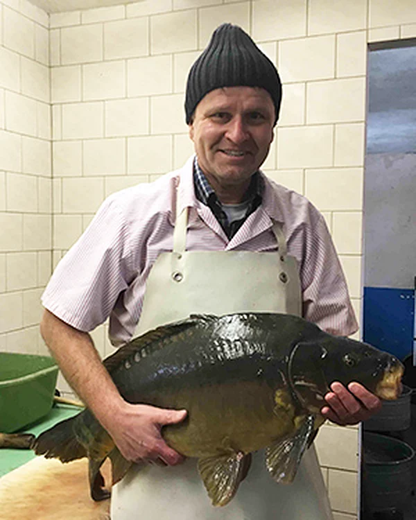 Romanus Weber mit einem Karpfen im Fischhaus Tautenhain